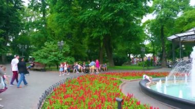 ODESA, UKRAINE - 18 Haziran 2021: Klasik çeşmeli, parlak çiçeklikli panorama, uzun yeşil ağaçlar ve arka plandaki yazlık ev 18 Haziran 'da Odesa' da