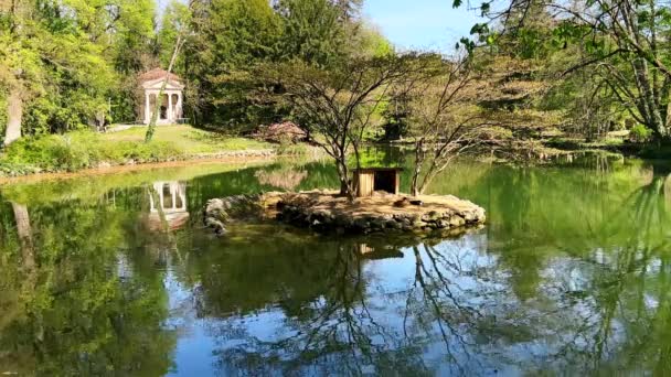 小さなイズレット イソレッタデッラ劇場 を持つ美しい鏡のような池 ラグトゥー ヴィラ レール 背景にある緑樹とドリック寺院 スワンレイク寺院 イタリア — ストック動画