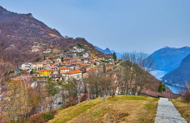 Bre 'nin kırmızı kiremit çatıları ve renkli evleri dağ manzarası, Lugano Gölü ve Monte Boglia yamacı, Ticino, İsviçre