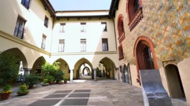 Ortaçağ Palazzo Borromeo Sarayı 'nın panoramasında duvarda, atari salonlarında, taş sütunlarda ve saksılarda korunmuş freskler, Milan, İtalya