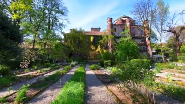 Arkaplanda Brera Obsrvatory 'nin tuğladan yapılma binası olan yemyeşil Brera Botanik Bahçesi Panoraması, Milan, İtalya