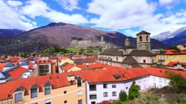Bellinzona 'nın klasik kırmızı çatıları, tepenin üstünde Castelgrande kalesi ve arka planda Alpler, Bellinthe, Ticino, İsviçre