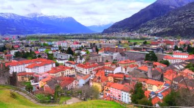 Kırmızı fayanslı çatıları ve arka planda Alpleri olan Bellinzona 'nın tarihi mahallesi, Ticino, İsviçre