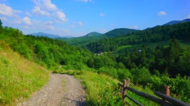Karpatlar 'da Chornohora Dağları' nın yeşil dağ çayırları ve kozalaklı ormanlarının panoramasında Smotrych ve Pip Ivan, Dzembronia, Ukrayna siluetleri bulunur.
