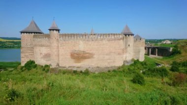 Arka planda parlak mavi Dniester Nehri olan Khotyn Kalesi 'nin yüksek surlarının panoraması, Ukrayna