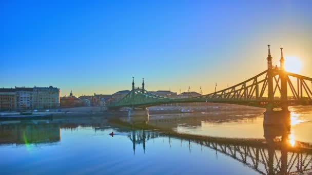 匈牙利布达佩斯的多瑙河全景 有着历史性的自由桥 太阳在它后面升起 佩斯区和白伊丽莎白桥的堤岸和住房 — 图库视频影像