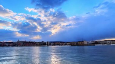 Budapeşte 'de rüzgarlı bir akşam. Parlak alaca karanlık gökyüzü, hızlı akan bulutlar ve Macaristan' ın Tuna Nehri 'nin dalgalı yüzeyi.
