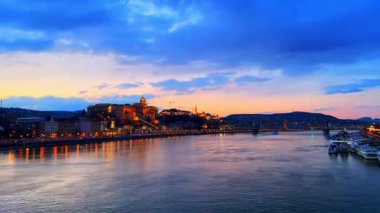 Zaman çizelgesi Elisabeth Köprüsü 'nde yürüyor, Tuna Nehri' nin dalgalı yüzeyini inceliyor ve Budapeşte, Macaristan 'da, mor alacakaranlıkta Castle Hill' in tepesinde Buda Kalesi 'ni aydınlatıyordu.