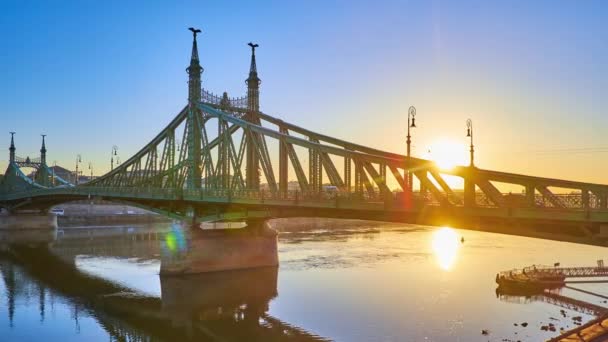 ハンガリー ブダペスト ブダペストの日の出にダヌーブ川の表面とペストのエンバンクに反映されたリバティ橋のタイムラプスパノラマ — ストック動画