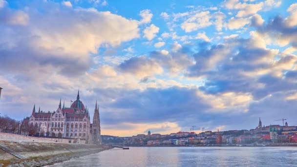 明るい曇りの日没の空のタイムラプス ゴシック議会の建物 ダヌーブ川とブダ城の上に走り 城の丘 ブダペスト ハンガリーの背景に見られる — ストック動画