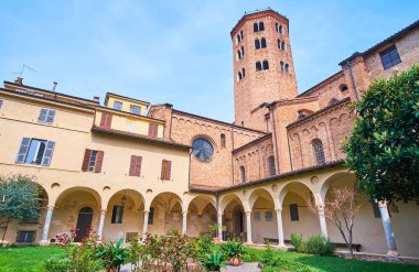 St. Antoninus Bazilikası 'nın ortaçağ avlusunda küçük bir bahçesi, kemerli galerileri ve kilise çan kulesi (çan kulesi), Piacenza, İtalya