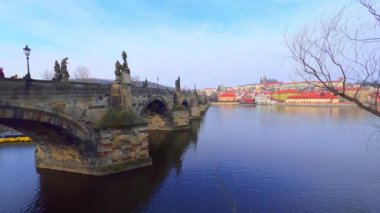 Çek Cumhuriyeti, Prag, Vltava Nehri 'ndeki Ortaçağ Kemerli Taş Köprüsü (Karluv Most) manzaralı nehir kenarındaki yürüyüşün tadını çıkarın.