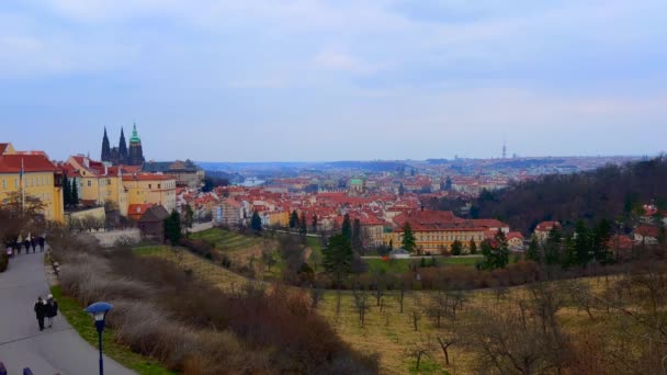 地平線 プラハ チェコ共和国の聖ヴィタス大聖堂の丘と背の高いゴシック様式の塔の斜面に大きなストラホフガーデンとプラハのパノラマの街並み — ストック動画
