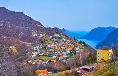 Monte Bre yamacındaki renkli Alp Bre köyü dağlara karşı, Ticino, İsviçre