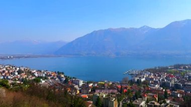 Puslu mavi Maggiore Gölü manzarası ve Locarno 'nun renkli çatıları. Küçük limanı ve Orselina dağ yerleşim yerinden gelen tekneleri, Ticino, İsviçre