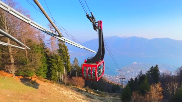 カルダ山の斜面にある森と 現代的な赤い空気ゴンドラ ティチーノ スイスに乗る 危険なマジョーレ湖のアルパイン風景 — ストック動画