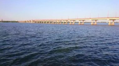 Dnieper Nehri 'nin derin mavi dalgalı yüzeyi. Arka planda Merkez Köprü, Dnipro, Ukrayna.