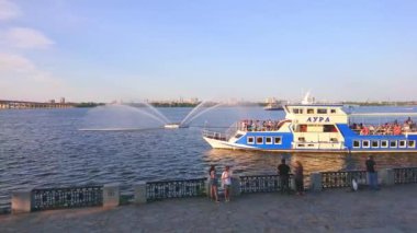 DNIPRO, UKRAINE - 24 Ağustos 2021: Sicheslav seti, 24 Ağustos 'ta Dinyeper Nehri' ni yüzen turist tekneleri ve manzaralı Beyaz Kuğu Çeşmesi ile gözlemler.