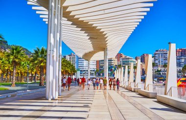 MALAGA, SPAIN - 28 SEPT 2019: Malaga Limanı boyunca uzanan ve olağandışı dalga benzeri beyaz tepe örtüsüyle süslenmiş kalabalık modern Palm Grove of Surprises gezinti alanı, Malaga, İspanya