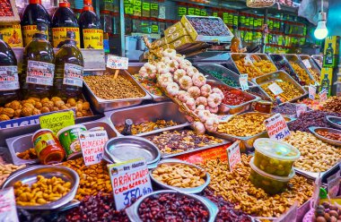 MALAGA, İspanya - 28 Eylül 2019: 28 Eylül 'de Malaga' da Atarazana merkez pazarında zeytin yağı, tuzlu zeytin, kuru üzüm, fındık, sarımsak ve baharat tezgahı