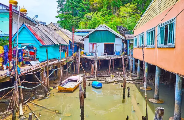 The shallow water amid the stilt houses is swamped with trash, Ko Panyi floating village, Phang Nga Bay, Thailand