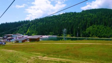 BUKOVEL, UKRAINE - 25 Temmuz 2021: Molodist (Gençlik) Gölü ve yeşil Karpat dağları boyunca 25 Temmuz 'da Bukovel' de asansör turları