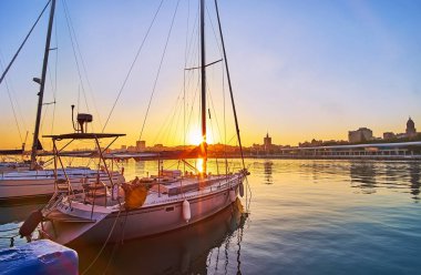 Günbatımını Malaga limanında gökyüzü ile seyredin, su yüzeyine ve modern yatlara yansıyan, Muelle Uno iskelesine demirlemiş, Costa del Sol, İspanya