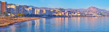 Yüksek binaları ve dağları olan popüler Malagueta Sahili manzarası yumuşak akşam ışıkları, Malaga, Costa del Sol, İspanya