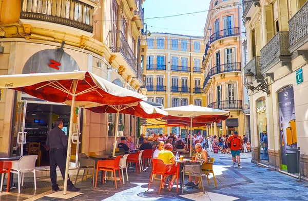 MALAGA, SPAIN - SEPT 28, 2019: Eski şehirde öğle yemeği saati - açık kafeler ve restoranlar insanlarla dolu, Calle Angel caddesinde, Malaga 'da 28 Eylül' de güneş gözlüğü altında oturuyorlar.
