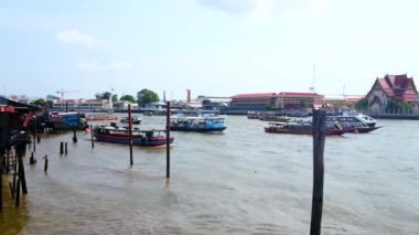 Chao Phraya nehir kenarı manzarası karşı kıyıdaki tekneler, feribotlar ve Budist Tapınağı ile, Bangkok, Tayland