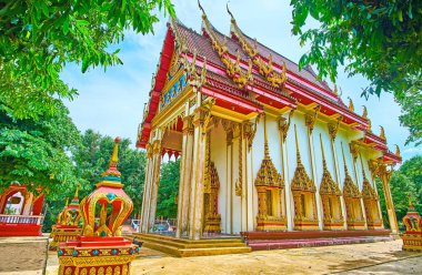 The Ubosot of Wat Suwan Kuha Temple with multi-tired roof, bargeboards with Naga serpents, ornate doorframes, Phang Nga, Thailand clipart