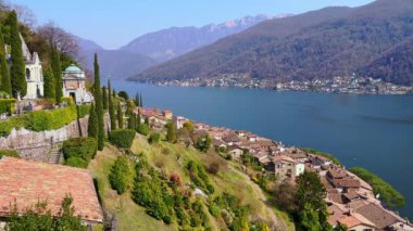Monumental Mezarlığı 'nın eski resimli mezarlarının olduğu dağ yamacı, Alpler, Morcote, İsviçre' nin ortasında yeşil bahçe ve Lugano Gölü.
