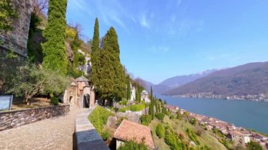 Morcote köyü panoraması Santa Maria del Sasso Kilisesi 'nin bakış açısından, anıtsal mezarlığı, yeşil dağ yamacını, fayans çatılarını ve Lugano Gölü, İsviçre