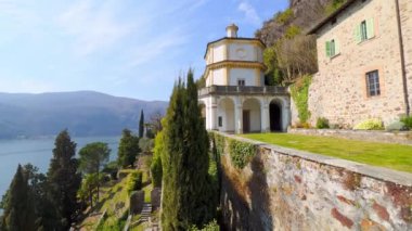 Dağ yamacında güzel teraslı Scherrer Parkı tepesinde Padua 'lı Aziz Anthony Kilisesi ve dağın eteğinde manzaralı gök mavisi Lugano Gölü, Morcote, İsviçre