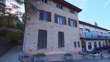 Çevresi kozalaklı bitkilerle çevrili Parco San Grato 'nun klasik binası ve yaya geçidi panorama - ardıçlar, eşkıyalar, Lugano Gölü ve Alpler manzaralı uzun çam ağaçları, Carona, İsviçre