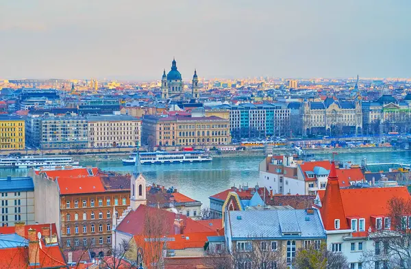 Balıkçı Kalesi, Tuna 'yı gemileriyle ve Pest siluetiyle Aziz Stephen Bazilikası, Budapeşte, Macaristan' ın kulesi ve çan kuleleriyle izliyor.