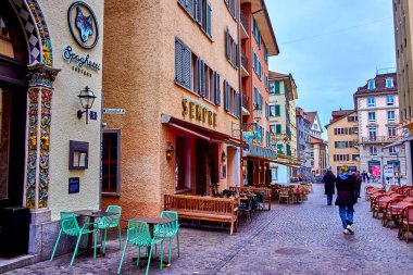 ZURİH, SWitzERLAND - 3 Nisan 2022: Niederdorfstrasse caddesi, 3 Nisan 'da İsviçre' nin Zürih kentinde, açık hava oturma yerleri olan sayısız büyüleyici kafe ve restoran