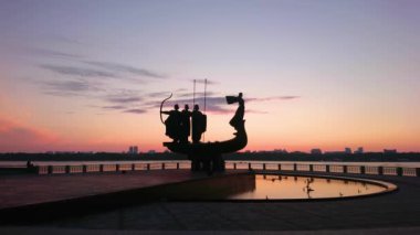Karanlık sabah gökyüzü parlak mor ve turuncu bulutlar ile Şehir Kurucuları Anıtı silueti ile önplanda, Kyiv, Ukrayna