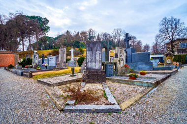 COLLINA D 'ORO, SWitzERLAND - 18 Mart 2022: Sant' Abbondio Mezarlığı, 18 Mart 'ta İsviçre' nin Collina d 'Oro kentinde heykellerle süslenmiş mezar taşlarını barındırıyor.