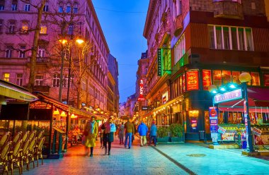 BUDAPEST, HUNGARY - 3 Mart 2022: Restoranları, kafeleri, barları ve hediyelik eşya dükkanları Budapeşte, Macaristan 'daki Vaci Caddesi' nde akşam yürüyüşünün tadını çıkarın