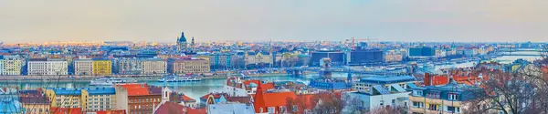 Amazing sunset panorama of the city with Buda roofs, Danube with bridges, Pest quarters and St Stephen Basilica, dominating the skyline, Budapest, Hungary