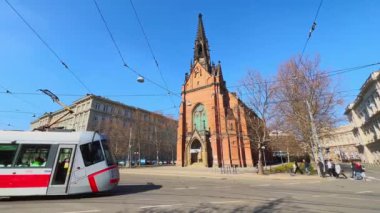 Comenius Meydanı 'nda Gotik Kızıl Kilise ve modern kırmızı tramvaya binen Brno, Çek Cumhuriyeti