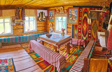 YABLUNYTSYA, UKRAINE - JULY 24, 2021: Panorama of the Hutsul house with wooden furniture, rugs, icons and rushnyk towels, Mountain Valley Peppers (Polonyna Pertsi) amusement park and handicraft village, on July 24 in Yablunytsya clipart
