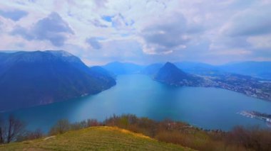 Lugano 'nun kuş bakışı görüntüsü, Lugano Gölü, Monte San Salvatore' un puslu silueti ve Monte Sighignola Monte Bre, Ticino, İsviçre 'nin tepesinden