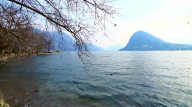 Lugano Gölü 'nün dalgalı sularının panoraması alacakaranlıkta Monte San Salvatore' a karşı, Lugano, Ticino, İsviçre