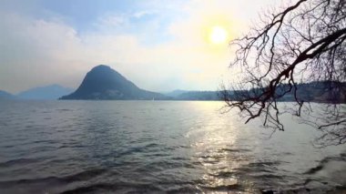 Lugano Gölü 'nde gün batımı ve güneş yolu Monte San Salvatore, Lugano, İsviçre' ye karşı.