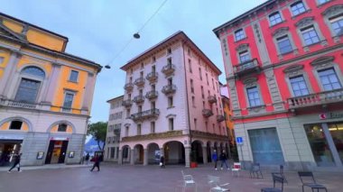 LUGANO, SWitzERLAND - 14 Mart 2022: Piazza della Riforma Panoraması (Riforma Meydanı) renkli tarihi binalar, Palazzo Civico (Belediye Binası), açık hava restoranları, bankalar ve turist dükkanları, 14 Mart 'ta Lugano' da