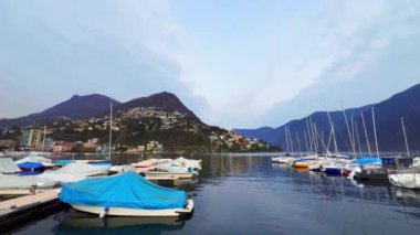Lugano Gölü 'ndeki limanda demirlemiş yatların arkasında Monte Bre ve Monte Boglia, Lugano, Ticino, İsviçre