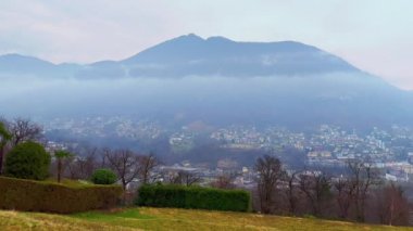 Monte Bre, Monte Boglia ile sisli dağ manzarası manzarası, Lugano Gölü ve Lugano Gölü 'nün çatıları Porza Dağı yerleşiminin arka planında, Ticino, İsviçre
