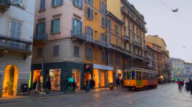 Tarihi Corso Magenta caddesinde, eski evler, yoğun trafik ve eski sarı tramvayla dolu bir akşam, Milan, İtalya